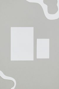 Stylish minimalist layout featuring white paper on a gray background with ample copy space.